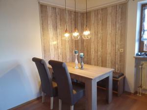 a dining room table with two chairs and lights at Landhaus Rißbachtal in Bodenmais +13 photos