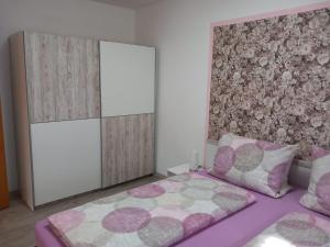 ein Schlafzimmer mit einem lila Bett und einer Wand in der Unterkunft Landhaus Rißbachtal in Bodenmais