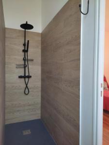 a shower with a wooden wall with a black fixture at La Provinciale en Ville in Montélimar +9 photos