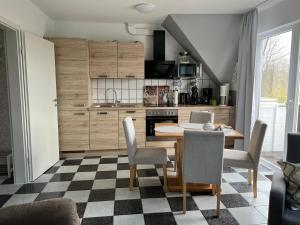 eine Küche mit einem Tisch und Stühlen im Zimmer in der Unterkunft Im Heidedorf Haus to Baben in Cuxhaven