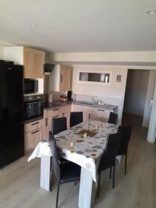 eine Küche mit einem Tisch und Stühlen sowie ein Esszimmer in der Unterkunft bien-être de l'Aveyron in Aguessac