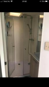 a bathroom with a shower with a glass door at Chalet 4-6 personen op 5* camping Terspegelt in Eersel