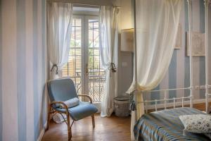 フィレンツェにあるRENAISSANCE FLORENCE APARTMENTのベッドルーム1室(ベッド1台、椅子、窓付)