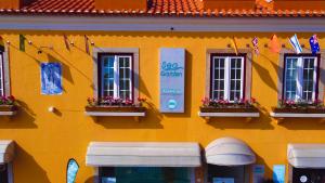 a yellow building with windows and flags on it at Sea Garden Peniche in Peniche