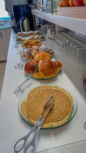 a table with plates of pancakes and croissants on it at Sea Garden Peniche in Peniche