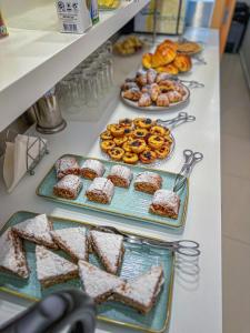 a buffet line with different types of pastries and donuts at Sea Garden Peniche in Peniche