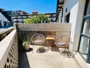 a patio with two chairs and a table on a balcony at Industrial CHIC Apartment 113 in Johannesburg