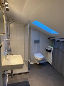 a bathroom with a sink and a toilet and a blue light at Ferienwohnung Auf der Heide in Ehringshausen +8 photos