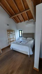 una camera con un grande letto e un pavimento in legno di Casa de baixo studios a Arouca