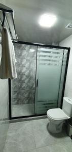 a bathroom with a shower with a toilet and a glass shower stall at Hotel Byond Tashkent in Tashkent +29 photos