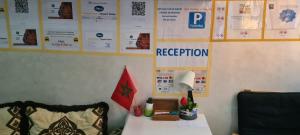 einen Schreibtisch mit einer Lampe und Plakaten an einer Wand in der Unterkunft chambres d'hôtes aéroport Mohammed V in Deroua