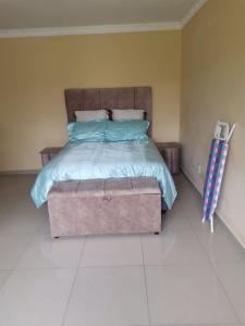 a bedroom with a bed with a box at the end at Phakathi Lifestyle Village Umnini in Amanzimtoti +9 photos