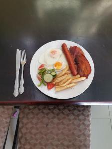a plate of breakfast food with eggs sausage and french fries at Phakathi Lifestyle Village Umnini in Amanzimtoti