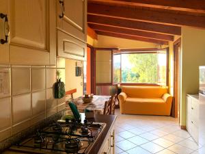 cocina con fogones horno de arriba junto a un sofá en Residenza Bea, en Flumini di Quartu