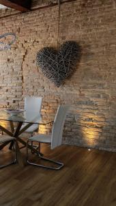 a table and a chair with a heart on a brick wall at Ca' Monica Apartment in Venice