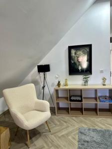 Televízia a/alebo spoločenská miestnosť v ubytovaní Au coin de la rue