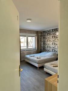 1 Schlafzimmer mit 2 Betten und einem Fenster in der Unterkunft Au coin de la rue in Rhinau
