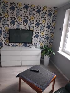 a living room with a flat screen tv on a wall at Apartament w centrum in Koszalin