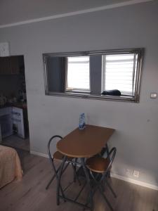 a table and two chairs in a room with a window at Apartament w centrum in Koszalin