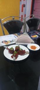a black table with two plates of food on it at Drishtee Homestay in Rongli +30 photos