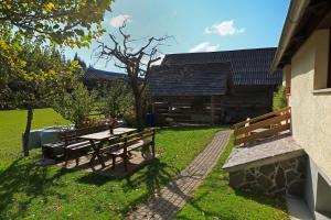 a picnic table and benches next to a building at Cottage Zoja in Bohinjska Bistrica