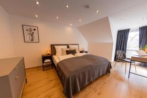 um quarto com uma cama, uma secretária e uma janela em BONNYSTAY Landshut Monument em Landshut