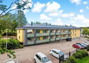 a building with cars parked in a parking lot at Saimaa Harbour apartment - AC, WiFi, Balcony & City Centre in Lappeenranta