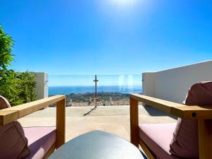 a balcony with a cross and a view of the ocean at Bayview - Unique Top modern duplex penthouse with sea views and a private hot tub by Solrentspain in Benalmádena