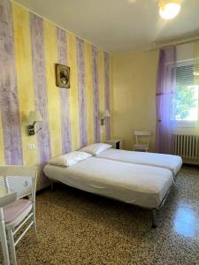 カヴァッリーノ・トレポルティにあるBungalows Alloggi Angiolin Kettyのベッドルーム(大型ベッド1台、椅子付)