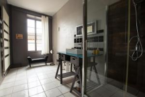 ein Bad mit Dusche und ein Schreibtisch in einem Zimmer in der Unterkunft Le Clos'art in Vinassan