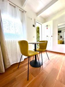 a dining room with a table and two yellow chairs at La Casa Particular in Bari