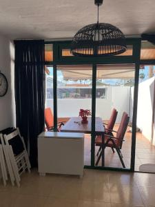 a dining room with a table and chairs and a clock at Entire townhouse in the paradise in Maspalomas