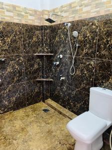 een badkamer met een toilet en een douche bij Rams Resort in Arugam Bay