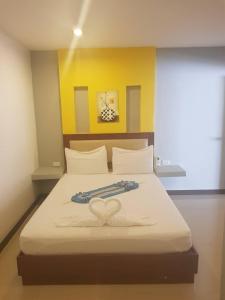 a bedroom with a bed with a heart decoration on it at Palm Inn in Ban Na Phong