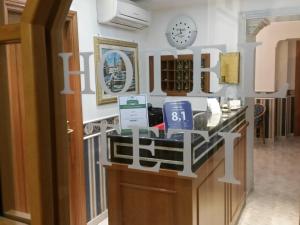 a room with a counter with a clock on the wall at Hotel Teti in Rome