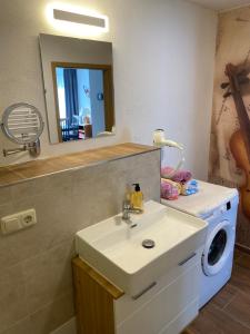 a bathroom with a sink and a washing machine at FeWo Roland Ranft direkt am Kurpark Barrierearm 60qm in Bad Elster
