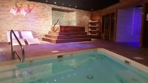 a swimming pool in a room with a piano at Domaine de la Forêt d'Orient, Logis Hôtel, Restaurant, Spa et Golf in Rouilly-Sacey