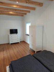 1 dormitorio con 1 cama, vestidor y TV en Ferienhaus Landsberg en Landsberg am Lech