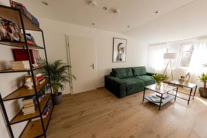 a living room with a green couch and a table at BONNYSTAY Landshut Monument in Landshut