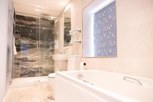 a white bathroom with a tub and a toilet at Marazion Hotel in Marazion