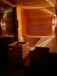 a wooden sauna with a bench and a tub at Villa Major in Göhren-Lebbin