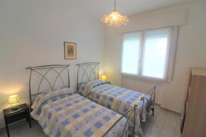 2 camas en una habitación con ventana en Villa Patrizia, en Lignano Sabbiadoro
