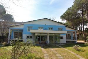 una casa azul y blanca con patio en Villa Patrizia, en Lignano Sabbiadoro