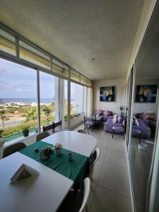 - un salon avec une table et un canapé dans l'établissement Melrose Beach - Apartment with a beach view, à Dar Bouazza