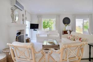 een woonkamer met witte meubels en een open haard bij Farm Lorraine Lake Cottage, Loft Cottage and Garden Cottage in Franschhoek