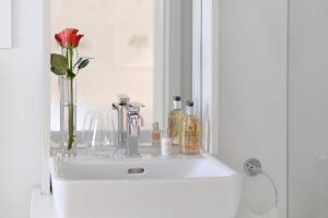 a bathroom sink with a vase with a flower on it at Farm Lorraine Lake Cottage, Loft Cottage and Garden Cottage in Franschhoek