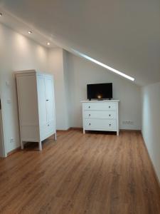 um quarto vazio com uma cómoda e uma televisão e uma cómoda em Ferienhaus Landsberg em Landsberg am Lech