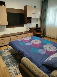 a living room with a table with a blue blanket at Adrian Home Mega in Ploieşti +29 photos