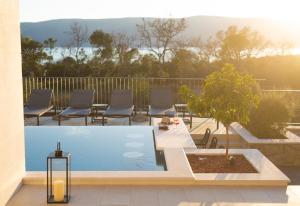 a swimming pool on a patio with chairs and a table at Luxury Villas LORD and LADY in Pinezici