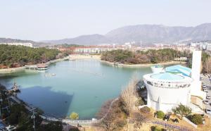 un gran cuerpo de agua con gente nadando en ella en Changwon Dean Hotel, en Changwon